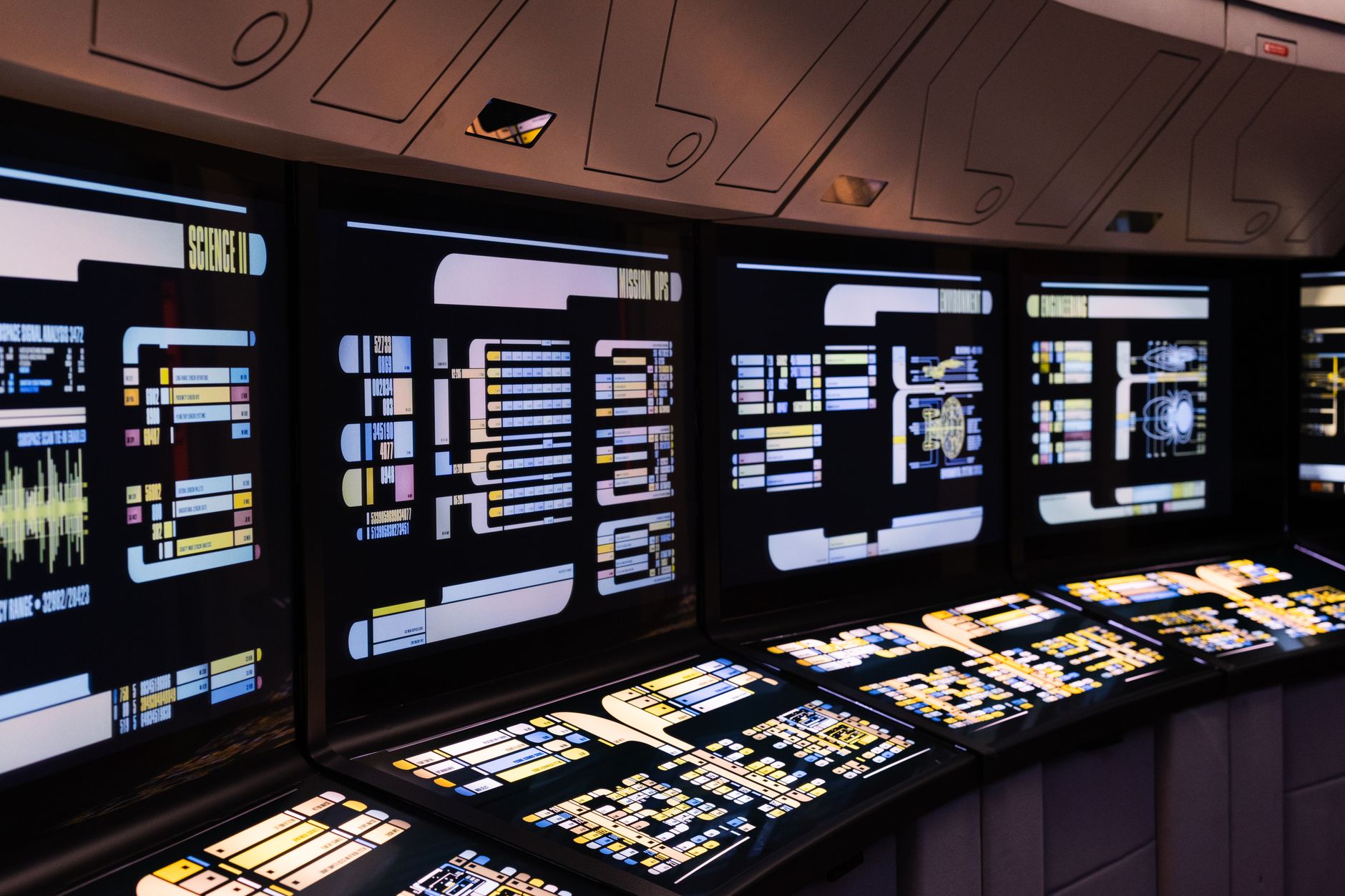 Bank of control-room screens showing operational monitoring panels